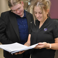 Two female staff reviewing questions